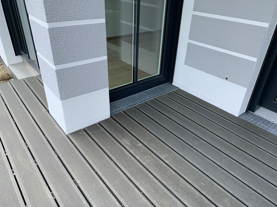 Dachterrasse mit grauem WPC-Belag auf Stelzlagern zwischen weißen Säulen