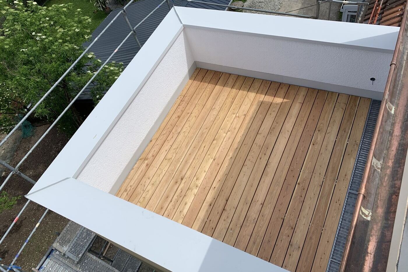 Fertige Loggia mit Lärchendielen und weißer Attikaverblechung